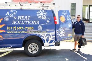 A AC & Heat Solutions tech near one of our trucks - Call now!