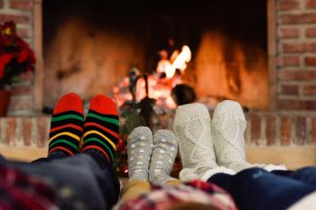 Family warming feet by fireplace. AC & Heat Solutions is ready to help with heating services at your home in Flower Mound. Call today!