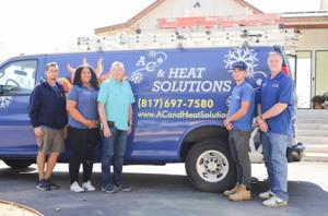 AC & Heat Solutions employees standing in front of a company truck - call now for heater replacement in Northeast Tarrant County